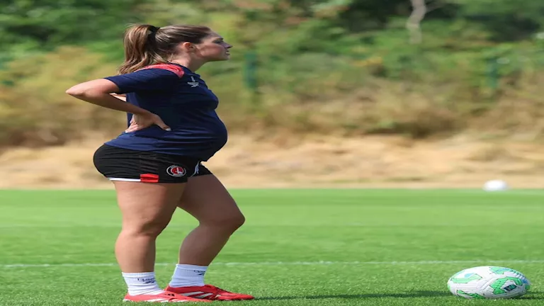 لاعبة كرة قدم تشارك في تدريبات فريقها وهي حامل